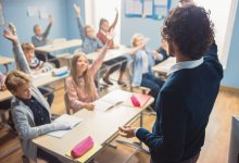 Teacher raising hand to get students' attention
