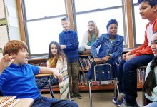 seven students in classroom talking