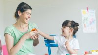 A woman and a young child play together.