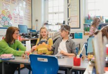 Science teacher working with a small group of elementary students at a table